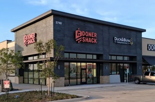 A signed Doner Shack storefront at 3740 in Prosper, Texas, with a dark interior and boarding against the glass